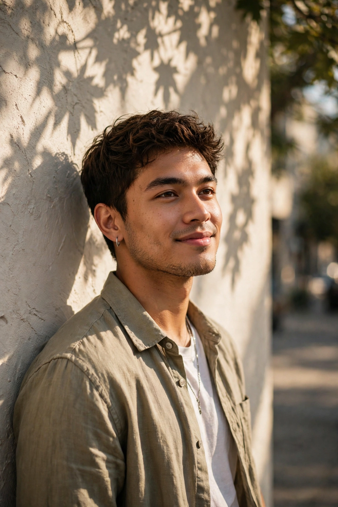 Create an ultra-realistic cinematic photograph of a stylish young man in a casual shirt posing by a sunlit wall with shadows of leaves, confident rela