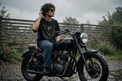 A moody, cinematic, ultra-realistic photograph of a young man with curly hair and sunglasses sitting on a black retro motorcycle during a rainy