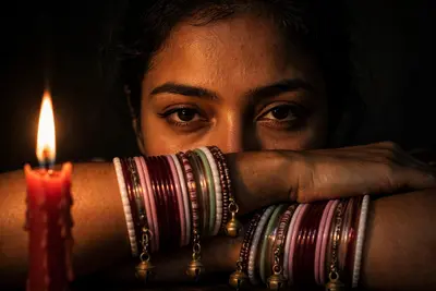 Create Ultra-realistic cinematic closeup low-light portrait of a woman (the reference image given) sitting in complete darkness, illuminated only by